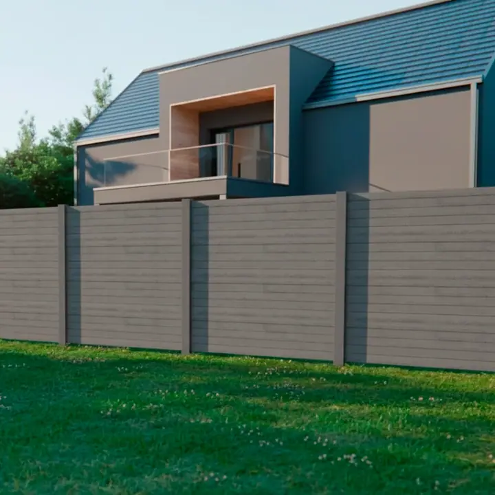 Muro pré-fabricado em Urban cinzento a fechar um jardim, visto de longe