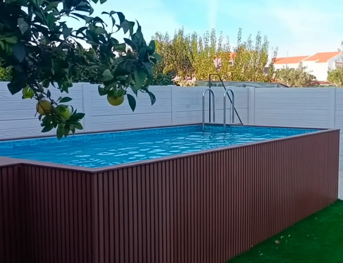 Muro modular em betão cinzento a delimitar a zona de piscina de uma moradia